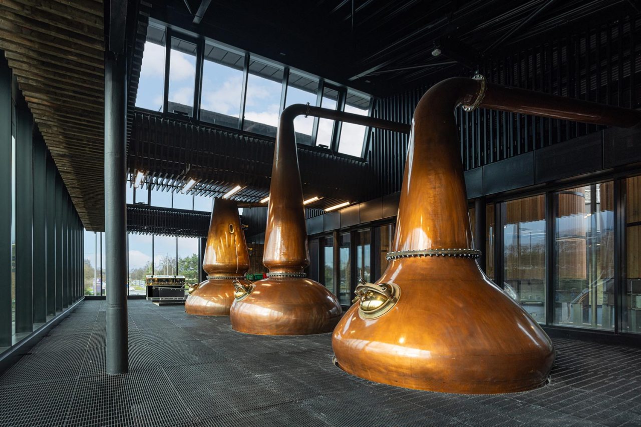 Three large whisky stills with glass roof above